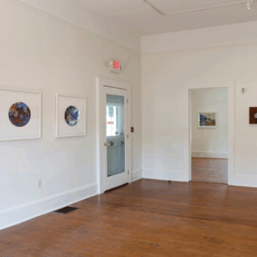 Preternatural exhibition hanging on walls next to doors in Spruill Gallery